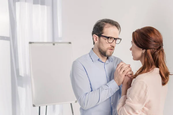 Homme d'âge moyen et femme tenant la main et se regardant — Photo de stock