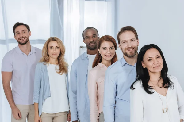 Multiethnic mid adult people standing together and looking at camera — Stock Photo