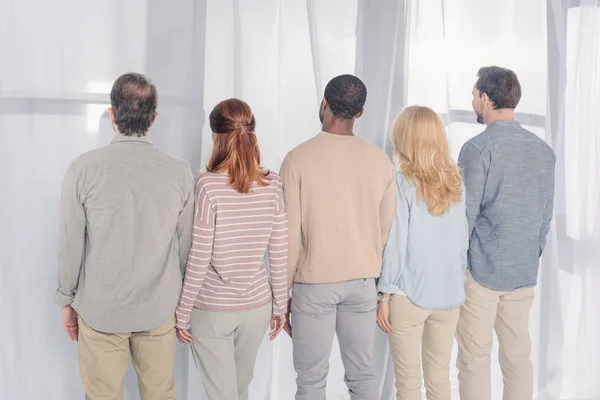 Rückansicht multiethnischer Menschen, die während der Gruppentherapie zusammenstehen — Stockfoto