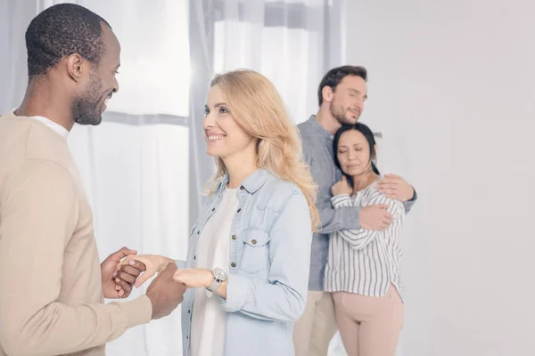 Paare mittleren Alters umarmen sich und halten Händchen, während sie sich gegenseitig unterstützen — Stockfoto