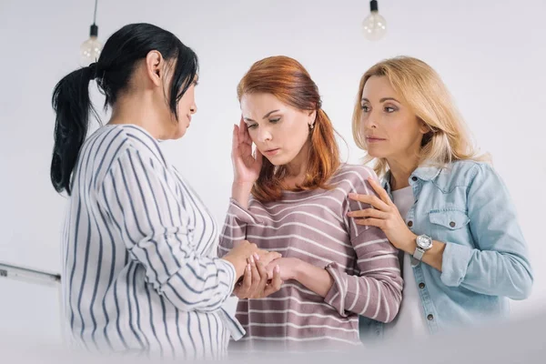 Mulheres multiétnicas de meia-idade apoiando chateado amigo feminino durante a terapia de grupo — Fotografia de Stock