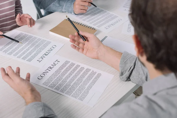 Partial view of middle aged people working with papers together — Stock Photo