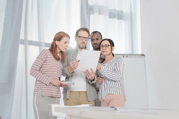 Des gens d'affaires multiethniques d'âge moyen discutant de documents ensemble — Photo de stock