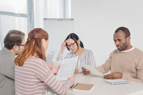 Groupe multiethnique d'âge moyen de gens d'affaires lisant des documents — Photo de stock