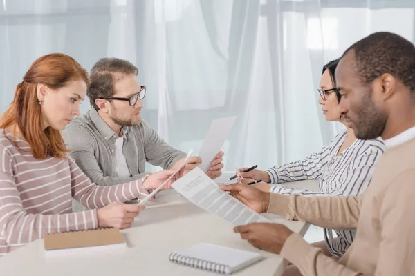 Groupe multiethnique d'âge moyen de gens d'affaires lisant des documents — Photo de stock