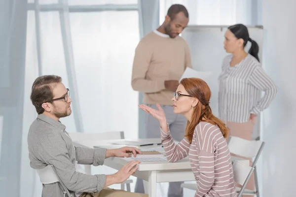 Side view of middle aged people talking while working together — Stock Photo