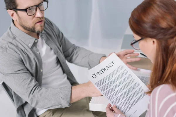 Empresarios de mediana edad con anteojos que trabajan con contrato juntos - foto de stock