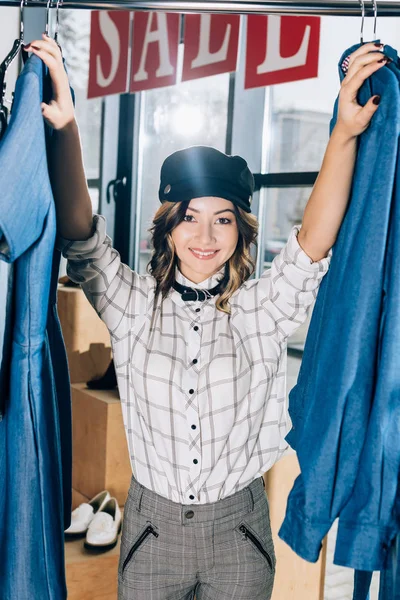 Sonriente joven en tienda de ropa el día de la limpieza - foto de stock