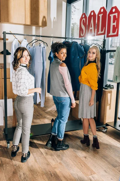 Groupe de jeunes femmes sur le shopping dans le magasin de vêtements — Photo de stock