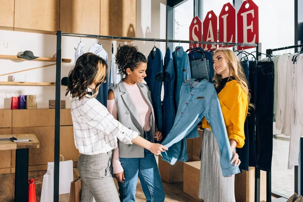 Grupo de adictos a las compras multiétnicas en tiendas de ropa - foto de stock