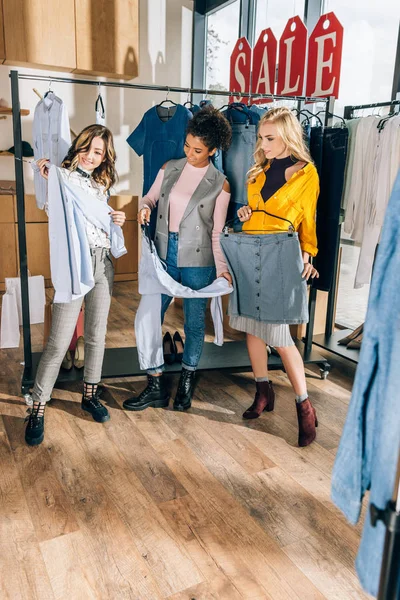 Grupo de mujeres con estilo en las compras en la tienda de ropa - foto de stock