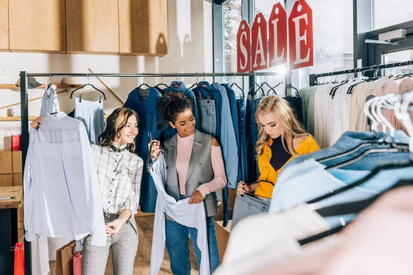 Group of beautiful stylish women on shopping in clothing store — Stock Photo