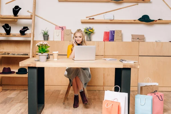 Gerente de la tienda de ropa hablando por teléfono en el lugar de trabajo - foto de stock