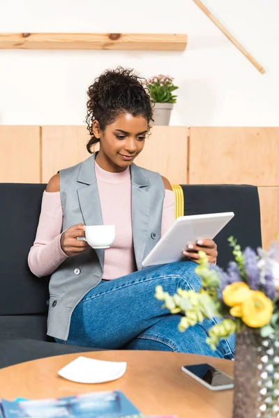 Belle jeune femme utilisant tablette et boire du café dans le café — Photo de stock