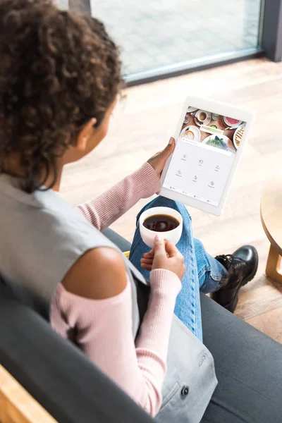 Bela jovem mulher usando tablet com forsquare app na tela — Fotografia de Stock