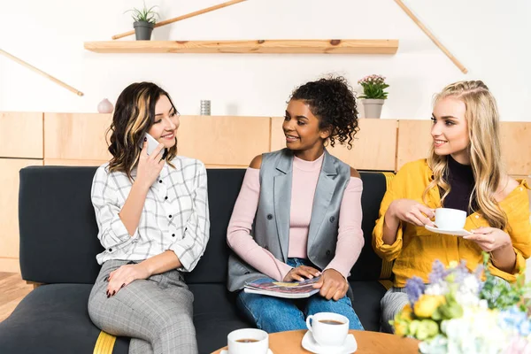 Group of young girlfriends spending time together in cafe — Stock Photo