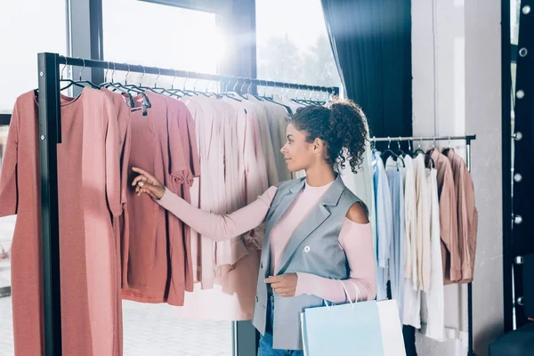 Hermosa joven en las compras en la tienda de ropa - foto de stock