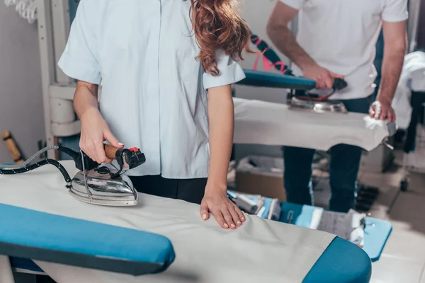 Schuss auf Reinigungskraft mit Industriebügeleisen im Lager — Stockfoto