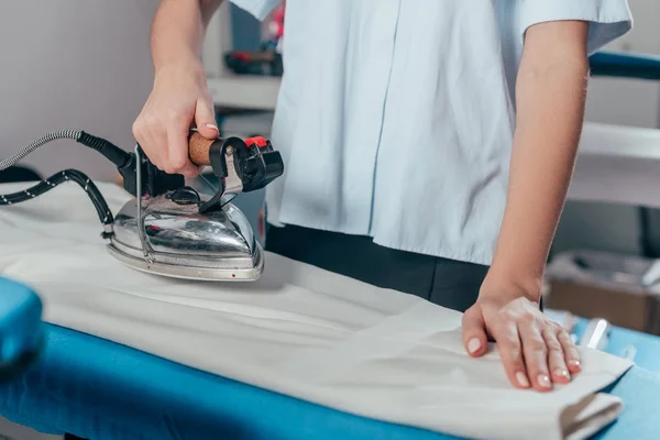 Cropped shot of female dry cleaning worker using industrial iron — Stock Photo