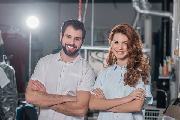 Travailleurs de nettoyage à sec avec les bras croisés debout à l'entrepôt — Photo de stock