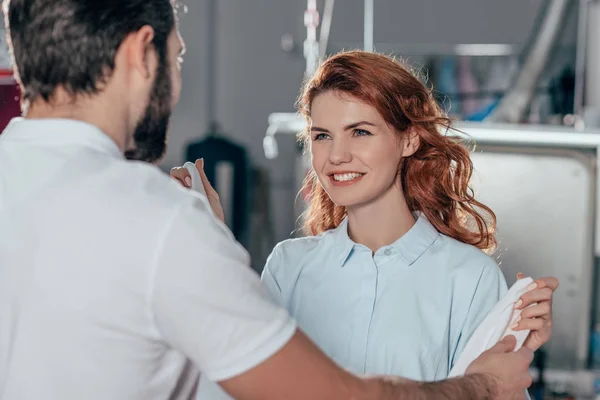 Young happy dry cleaning workers at warehouse — Stock Photo