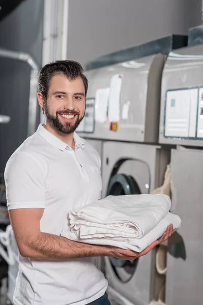 Reinigungskraft mit Stapel sauberer Kleidung — Stockfoto