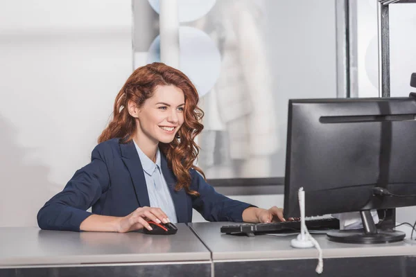 Jovem gerente feliz usando computador no local de trabalho — Fotografia de Stock