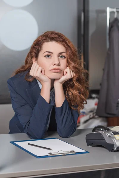 Gelangweilte junge Reinigungskraft sitzt am Arbeitsplatz — Stockfoto