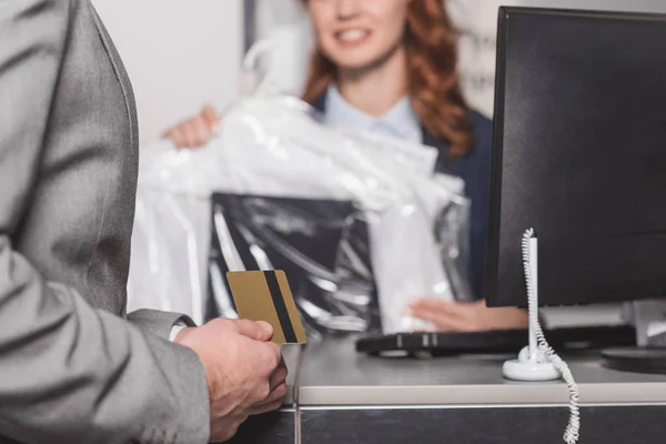 Cropped shot of man holding credit card at dry cleaning office — Stock Photo