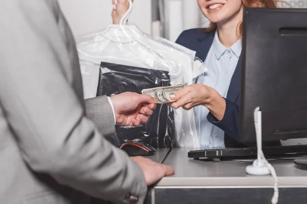 Cropped shot of dry cleaning manageress taking cash for order — Stock Photo