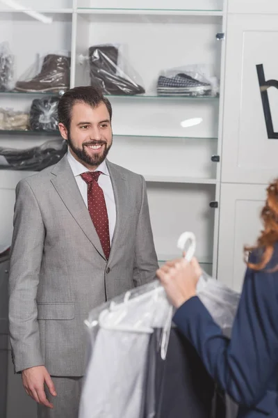 Nettoyage à sec managère sac de transport avec des vêtements au client — Photo de stock