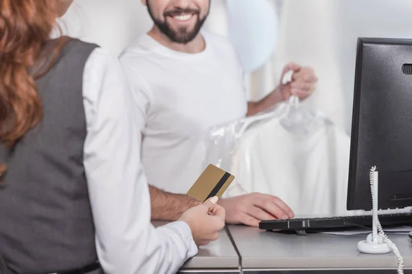 Cropped shot of woman giving credit card to dry cleaning manager — Stock Photo