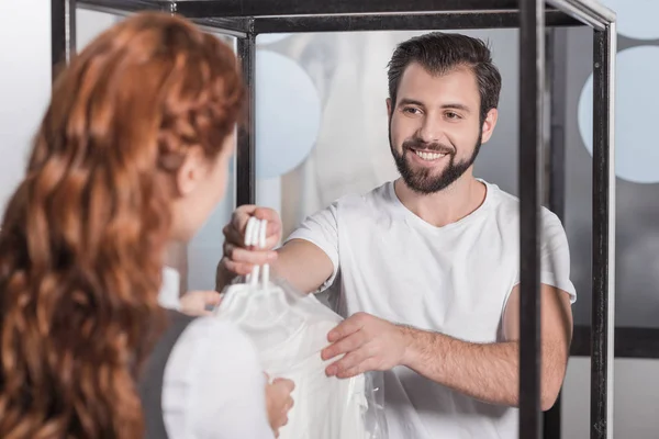 Gerente de limpieza en seco dando ropa al cliente - foto de stock