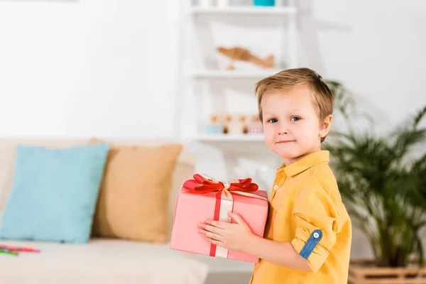 Side view of little boy holding wrapped present in hands — Stock Photo