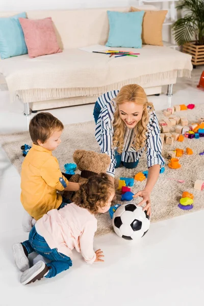 Blick von oben auf Mutter, die mit Kindern mit Fußball spielt — Stockfoto