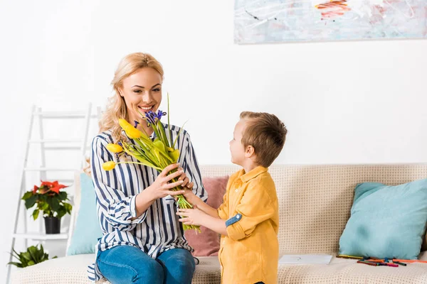 Sohn schenkt Mutter Blumenstrauß am Muttertag — Stockfoto