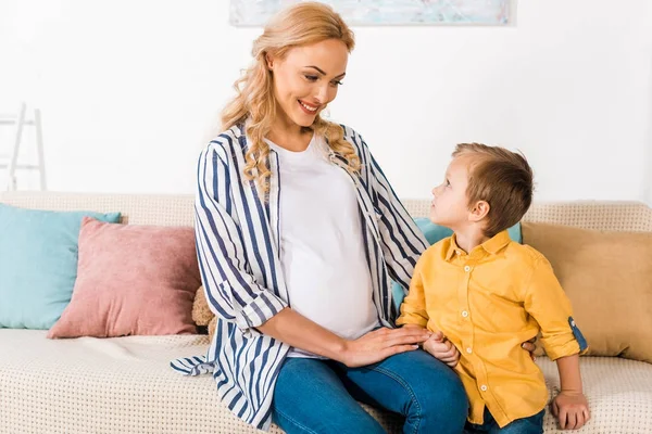 Smiling pregnant mother and son looking at each other — Stock Photo