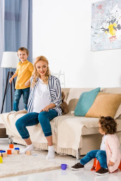 Pregnant mother looking at daughter sitting on pot — Stock Photo