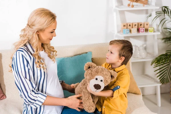 Schwangere Mutter präsentiert Sohn Teddybär — Stockfoto
