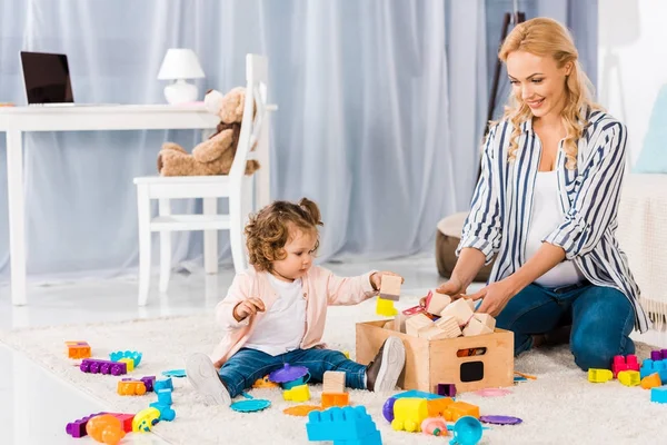 Happy pregnant mother playing with small daughter — Stock Photo