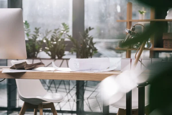 Blueprints and computer at workplace in modern architect office — Stock Photo