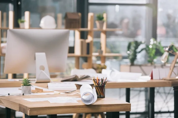 Plantas, documentos e computador no local de trabalho no escritório de arquitetos modernos — Fotografia de Stock