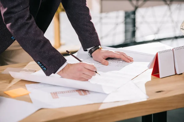 Ausgeschnittene Ansicht von Architekten, die Baupläne am Arbeitsplatz zeichnen — Stockfoto