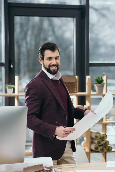 Male architect working with blueprint in modern office — Stock Photo