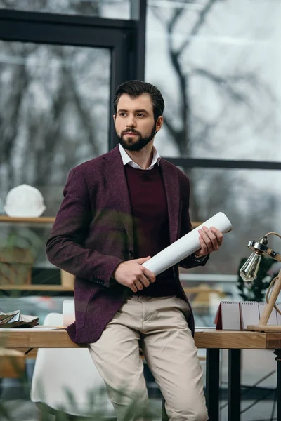 Architecte réfléchi tenant le plan directeur dans le bureau moderne — Photo de stock