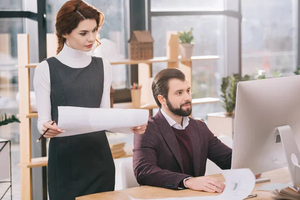 Due architetti che lavorano con cianografie e computer in uffici moderni — Foto stock