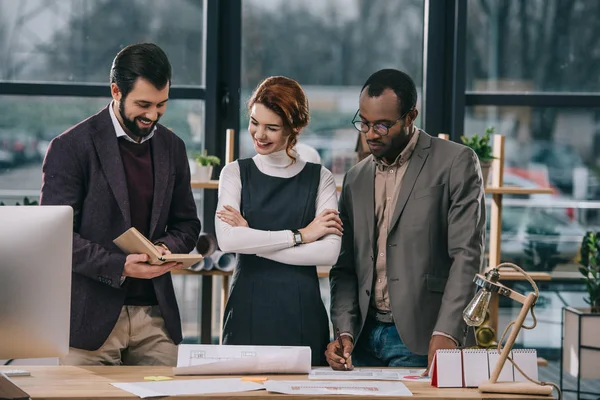 Multiethnic architects discussing work in modern office — Stock Photo