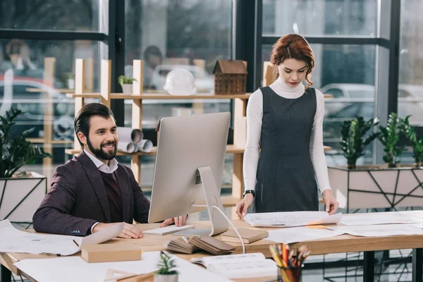 Architectes travaillant avec des plans informatiques et de construction dans un bureau moderne — Photo de stock