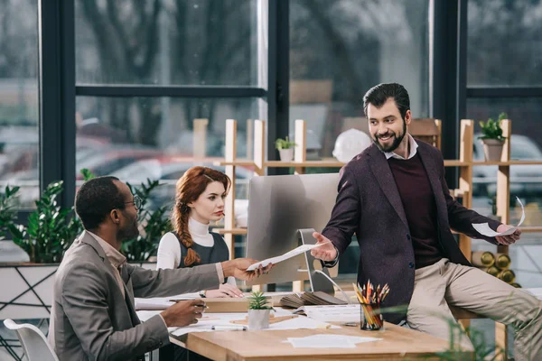 Arquitectos multiétnicos discutiendo planes de construcción en oficinas modernas — Stock Photo