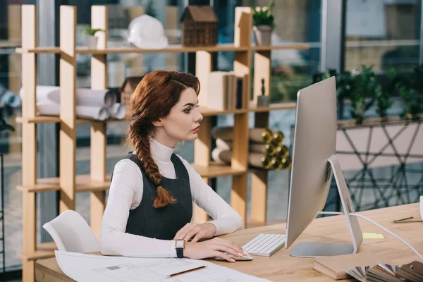 Architektin arbeitet mit Computer und Bauplan im modernen Büro — Stockfoto